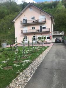 ein großes rosafarbenes Gebäude mit Bäumen davor in der Unterkunft Vila Jakovljević in Jošanička Banja