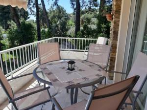 a table and four chairs on a porch with a table at Palio Villa in Paleo Tsifliki