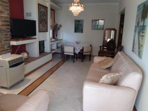 a living room with a couch and a tv at Palio Villa in Paleo Tsifliki