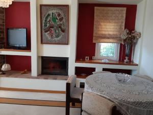 a living room with a table and a fireplace at Palio Villa in Paleo Tsifliki