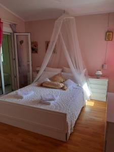a bedroom with a bed with a mosquito net at Palio Villa in Paleo Tsifliki