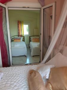 a bedroom with two beds and a large mirror at Palio Villa in Paleo Tsifliki