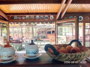 a bowl of fruit sitting on a table with a tea pot at Lozyata Guest House in Obzor