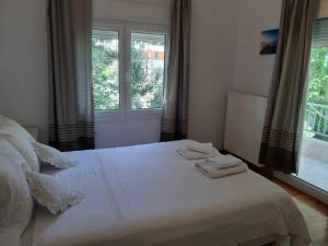 a bedroom with a white bed with two towels on it at Palio Villa in Paleo Tsifliki