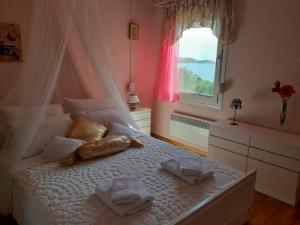 a bedroom with a bed with towels and a window at Palio Villa in Paleo Tsifliki