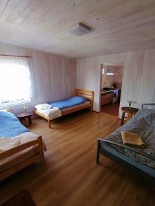 a bedroom with two beds in a room with wooden floors at Domek Stary Bar in Piecki