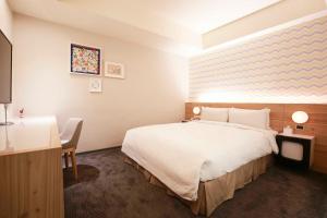 Rúm í herbergi á Dandy Hotel-Daan Park Branch