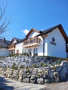a house with a stone wall in front of it at Karolowy pokoje&apartamenty in Ustroń