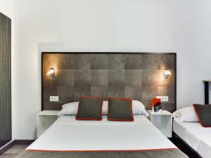 1 dormitorio con 1 cama blanca grande y 2 almohadas en Hello Feria en Madrid