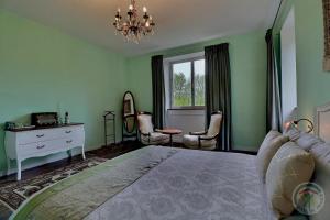 ein Schlafzimmer mit einem Bett, einer Kommode und einem Fenster in der Unterkunft Les voisins de l'illet in Ercé-près-Liffré