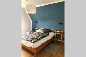 um quarto com uma cama com uma parede azul em 5-Zi. Wohnung in Bahnhofsnähe - 24/7 self-check-in em Borstel
