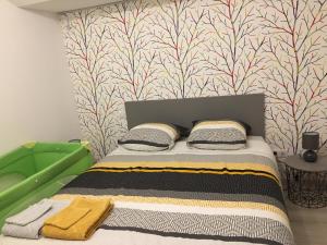 - une chambre avec un lit et un mur coloré dans l'établissement Gîte Évasion idyllique, à Faverolles-sur-Cher