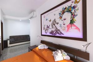 a bedroom with an orange bed and a large painting on the wall at A letto nell'Arte in Ascoli Piceno