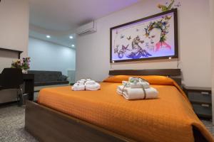 a bedroom with an orange bed with towels on it at A letto nell'Arte in Ascoli Piceno