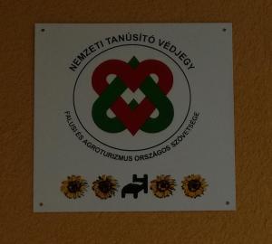 a sign on a wall that says embassy trinidad and tobiniaveve at Kaptárlevegős Vendégház in Füzesgyarmat