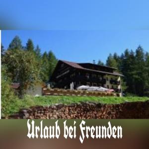 a large barn with a house in the background at Hotel - Apartment Sonnblick in Heiligenblut