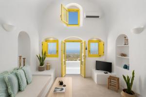 a living room with a yellow door and a tv at Valsamo Suites in Pyrgos