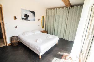 een slaapkamer met een wit bed en een raam bij LA GRANGE charme nature repos in Saché