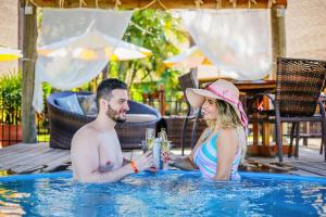 un uomo e una donna seduti in una piscina di Zagaia Eco Resort a Bonito