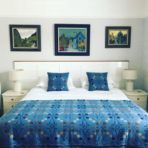 a bedroom with a bed with a blue and white comforter at Llety Brynawel Guest House in Pennal