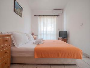 ブドヴァにあるMediterranean Guest House Balkanのベッドルーム1室(オレンジ色の毛布付きのベッド1台付)