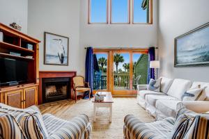 uma sala de estar com sofás, uma televisão e uma lareira em Mariner's Walk 8-E em Isle of Palms