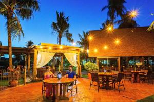 two people sitting at tables at a restaurant at night at Zagaia Eco Resort in Bonito