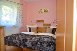 a bedroom with a bed and a desk with a window at Haus Bodner-Scherer in Mühlbach am Hochkönig