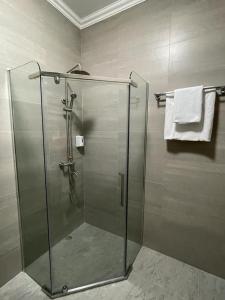 a shower with a glass door in a bathroom at SB River Hotels in Atyraū