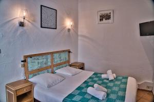 sypialnia z łóżkiem z dwoma ręcznikami w obiekcie Hôtel La Muette w mieście Arles