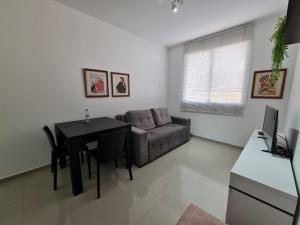 - un salon avec une table et un canapé dans l'établissement Belo Apartamento Eldorado II Master Collection, à Passo Fundo