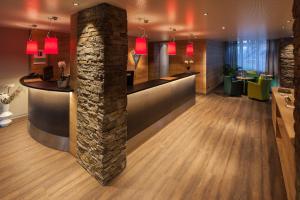 a lobby with a bar with a stone pillar at Alpine Hotel Perren in Zermatt