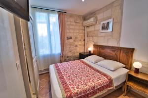 Un dormitorio con una cama grande y una ventana en Hôtel La Muette en Arlés
