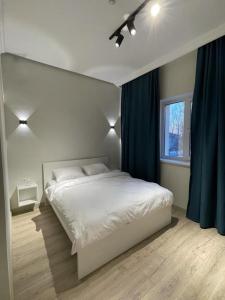ein Schlafzimmer mit einem weißen Bett und einem Fenster in der Unterkunft SB River Hotels in Atyrau