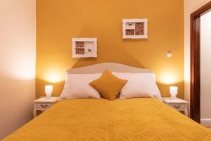una camera con letto e copriletto giallo di Cork Apartman a Eger