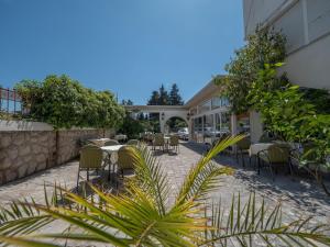 a patio of a restaurant with tables and chairs at Mediterranean Guest House Balkan in Budva