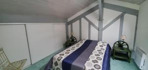 1 dormitorio con 1 cama con manta azul y blanca en Gite 4kms plage grand domaine privé lacs natura 2000, en Lit-et-Mixe