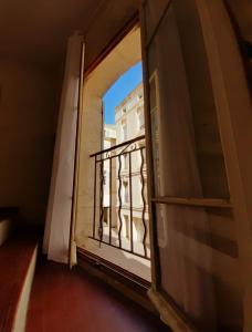 an open window with a view of a building at Le Quatrième - Avignon Intramuros in Avignon