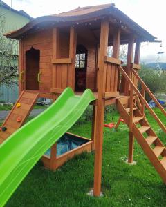 a play structure with a slide and a play house at Apartament KARINA in Tylicz