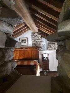an attic room with a bed and a stone wall at B&B la Forgia in Bettola