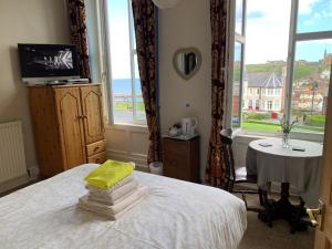 a bedroom with a bed with a view of the ocean at Khyber Mount Guest House in Whitby