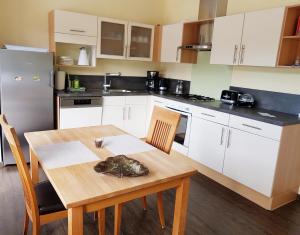 a kitchen with white cabinets and a wooden table at Ferienwohnung Wagner in Neumagen-Dhron