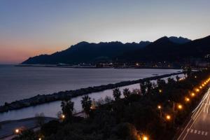 uma vista para a água e uma rua à noite em Suitesettepesciolini - Case vacanze Nemo e Dory em Salerno