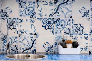 uma casa de banho com azulejos azuis e brancos e um lavatório. em Suitesettepesciolini - Case vacanze Nemo e Dory em Salerno