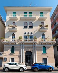 dos coches estacionados frente a un edificio en Suitesettepesciolini - Case vacanze Nemo e Dory, en Salerno