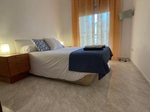 1 dormitorio con 1 cama, vestidor y ventana en Apartamento para 7 personas en Calafell, Barcelona., en Calafell