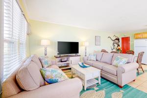 ein Wohnzimmer mit einem Sofa und einem TV in der Unterkunft Brooklyn's Casa Rosa & Hitch Apartment in Ocean City