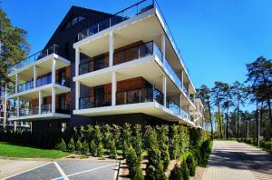 a large building with trees in front of it at Marina Apartments and Jet Ski in Augustów