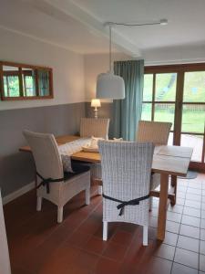 a dining room with a wooden table and chairs at Ferienhaus Deichblick in Tönning