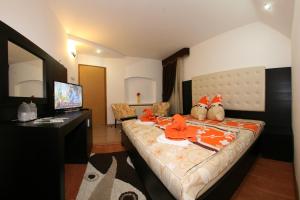 Una habitación de hotel con una cama con ropa de color naranja. en Pensiunea El Plazza, en Băile Herculane
